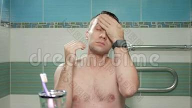 年轻有魅力的男人在酒<strong>店</strong>房间的浴室里洗过澡后，就会挺直发型。 他<strong>双</strong>手梳着头发